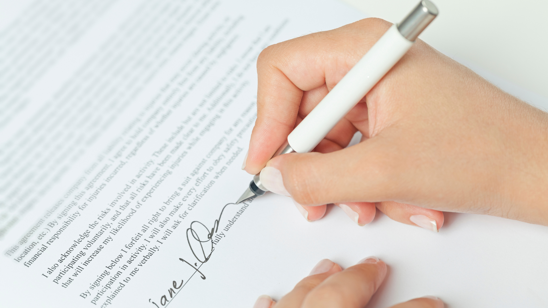 A close-up of a hand signing a document, symbolizing commitment and willingness to take ownership of one’s dream - Jillbosman.com