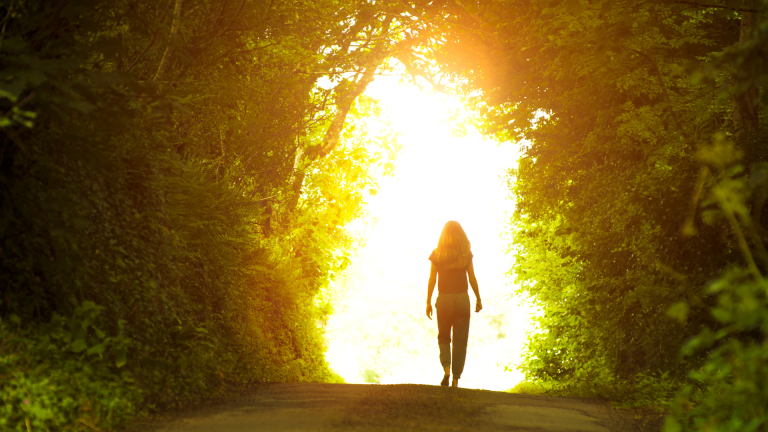 A woman walking out of a tunnel into sunlight, symbolizing the journey from limitation into possibility - jillbosman.com