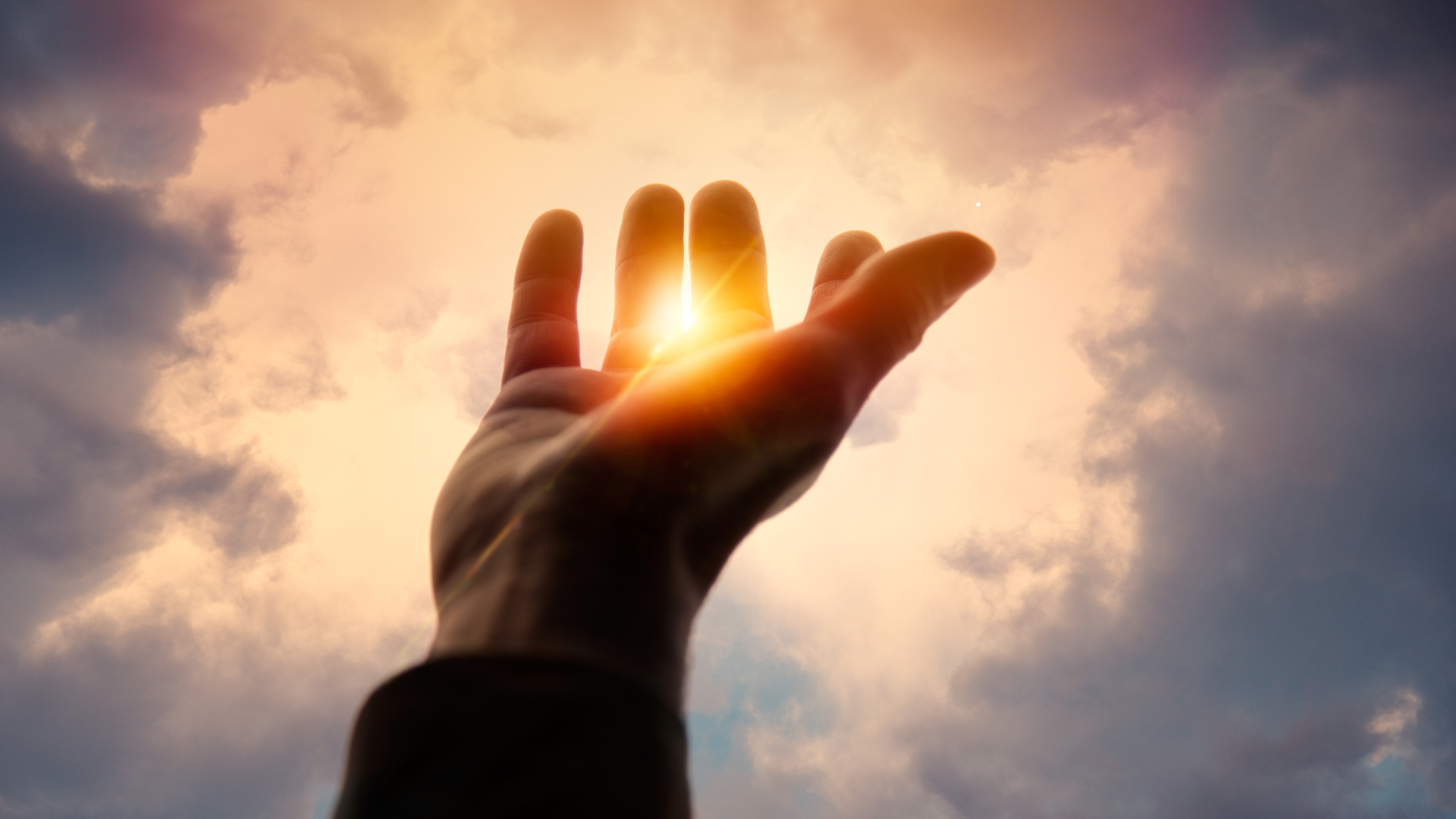 A woman standing with arms open in a sunlit field, representing openness to self-worth and receiving - jillbosman.com